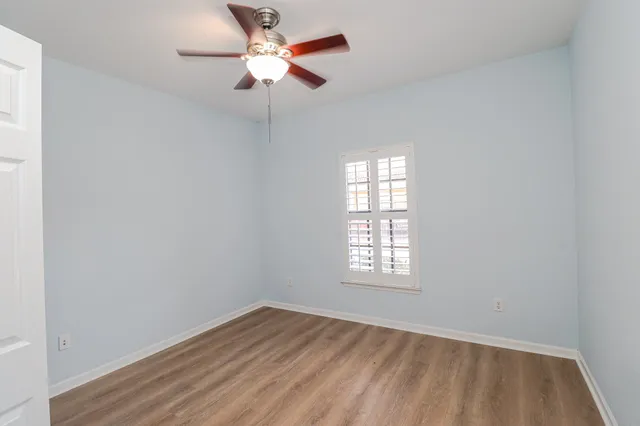an empty room with a window and a fan