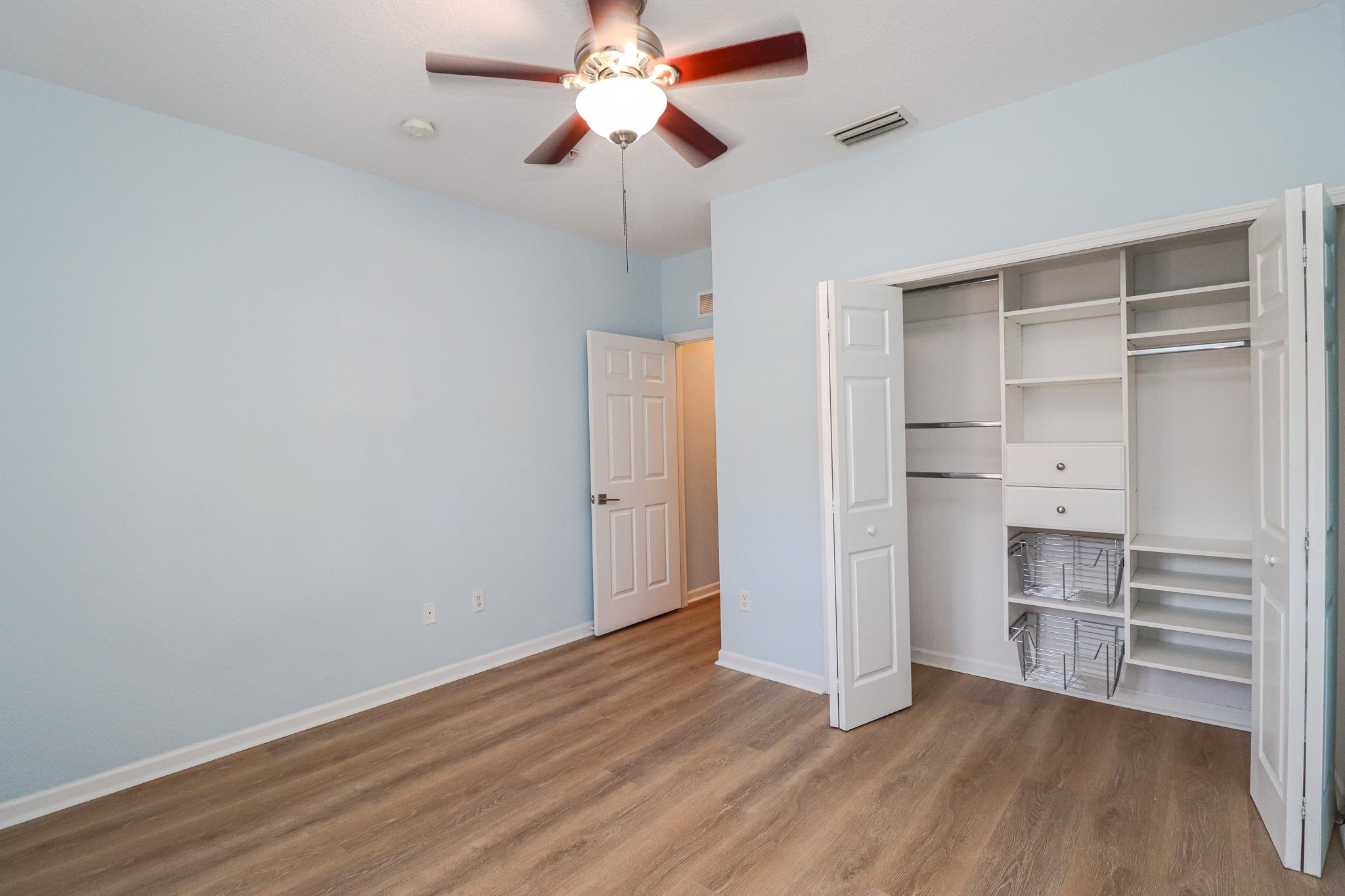 305 Via Castilla, Unit 103 St. Augustine, FL 32095 - Photo 27 of 34 a view of an empty room with a window and wooden floor