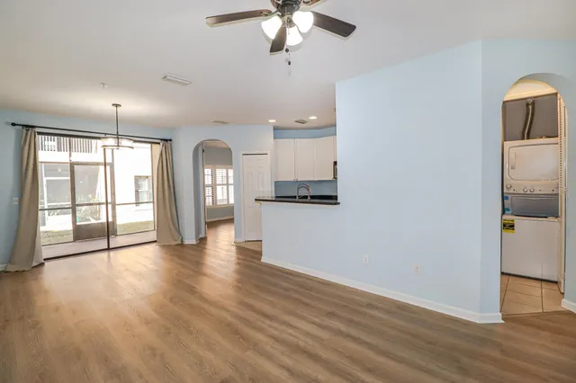 a view of an empty room with window and wooden floor