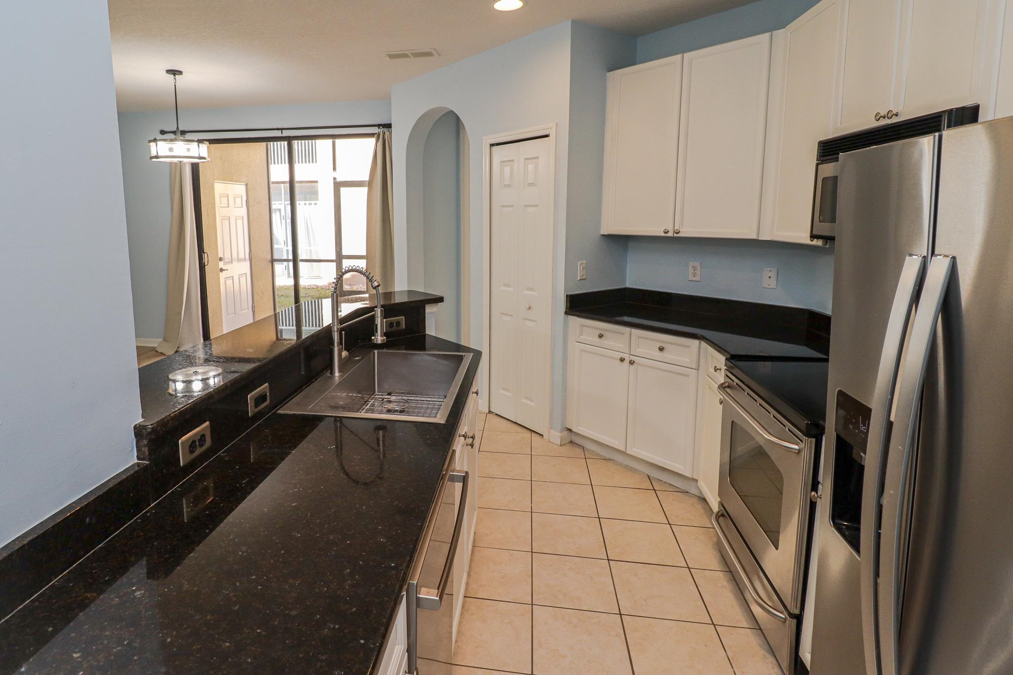 305 Via Castilla, Unit 103 St. Augustine, FL 32095 - Photo 9 of 34 a kitchen with a refrigerator a sink and cabinets