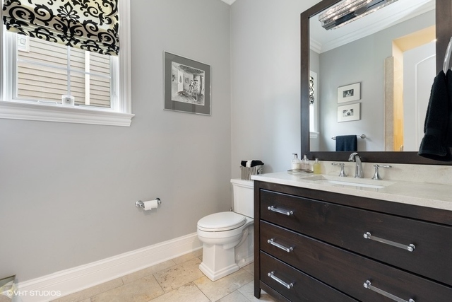 122 Walnut Street Elmhurst, IL 60126 - Photo 14 of 41 a bathroom with a granite countertop toilet a sink a mirror and a window