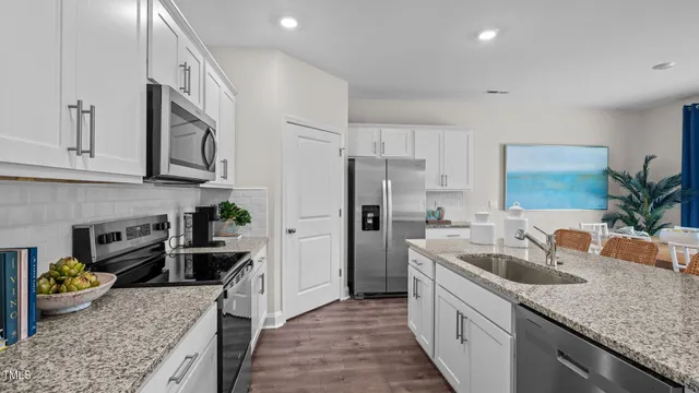a kitchen with stainless steel appliances granite countertop a sink stove and refrigerator