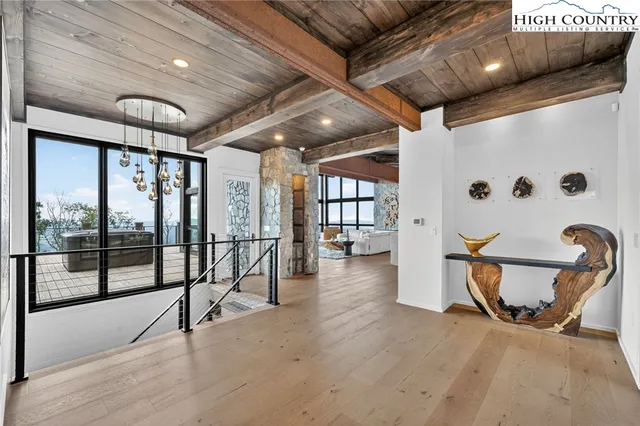 a view of a hallway with wooden floor and stairs