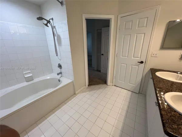 a bathroom with a granite countertop sink a toilet and bathtub