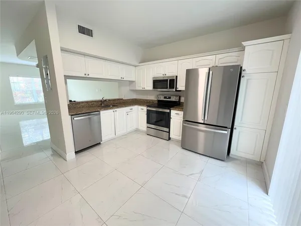 a kitchen with stainless steel appliances granite countertop a refrigerator sink and stove