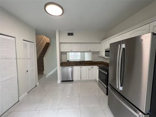 a kitchen with a refrigerator and a sink