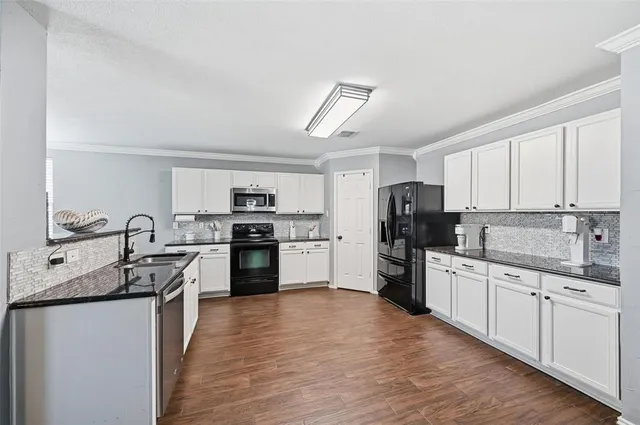 a kitchen with white cabinets and stainless steel appliances