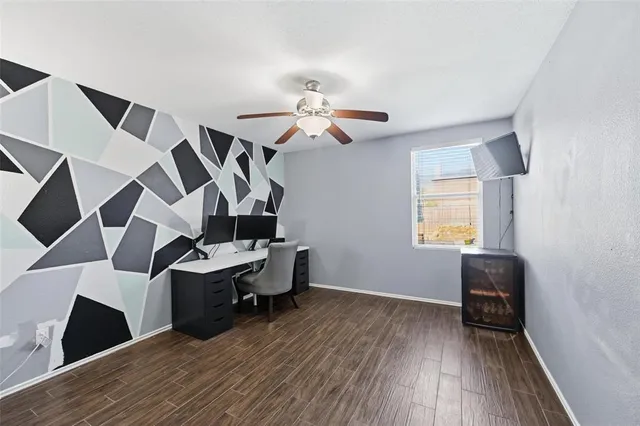 a view of a livingroom with a ceiling fan wooden floor and a ceiling fan