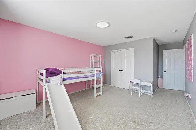 a bedroom with a bed and a large mirror with a dresser