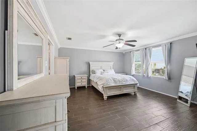 a bedroom with a large bed a flat tv screen and dresser