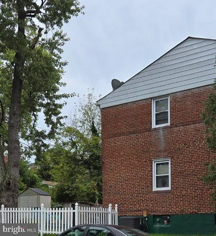 a brick house with a yard and wooden fence
