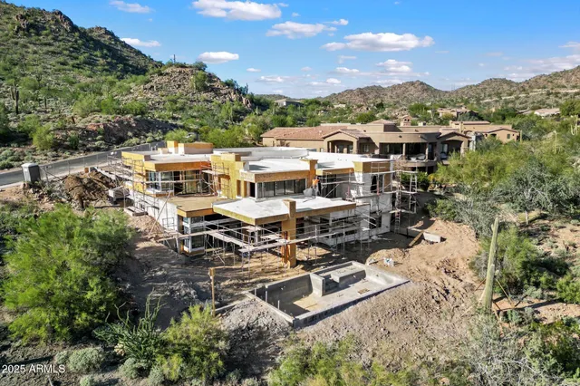 an aerial view of a house with a mountain