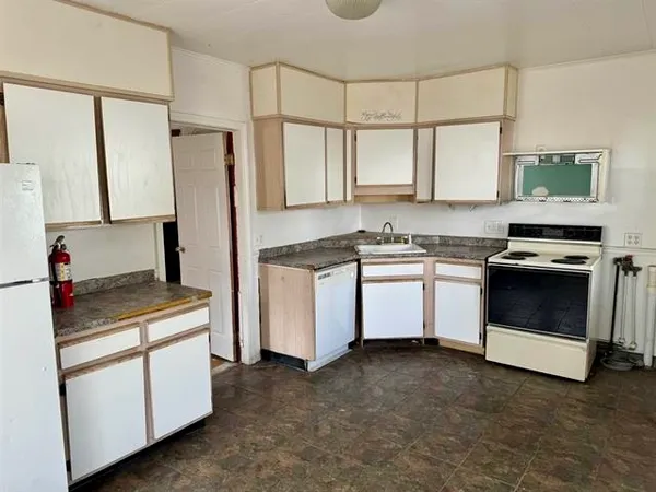 a kitchen with white cabinets and white appliances