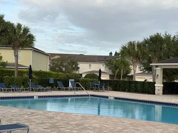 a view of a house with pool and a water fountain in front of it