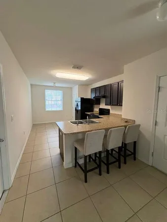 a dining room with a sink dishwasher a dining table and chairs