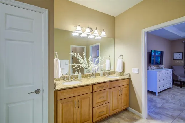 a bedroom with a bed and a lamp on dresser