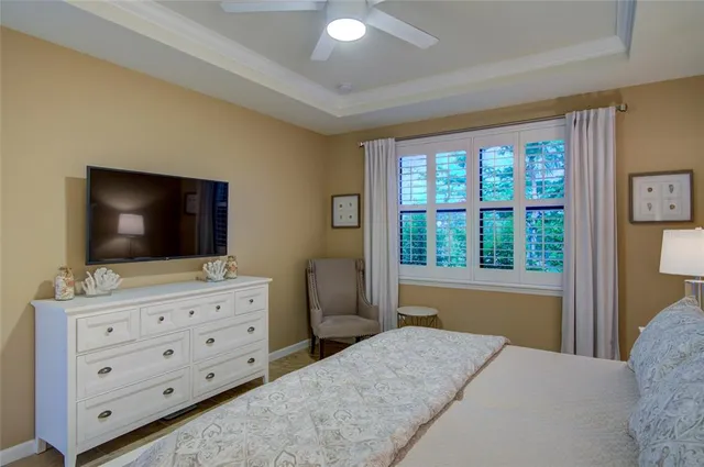 a bedroom with a bed and a flat screen tv on dresser