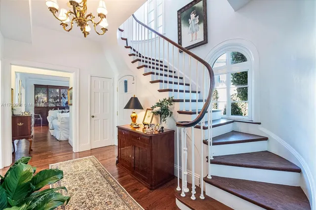 a view of a dining room with furniture a chandelier and wooden floor