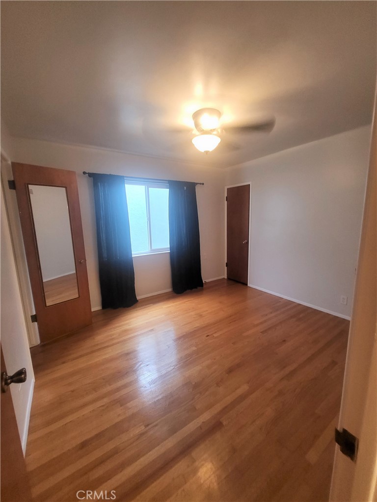 1057 East Appleton Street, Unit 7 Long Beach, CA 90802 - Photo 8 of 11 a view of an empty room with wooden floor and a window