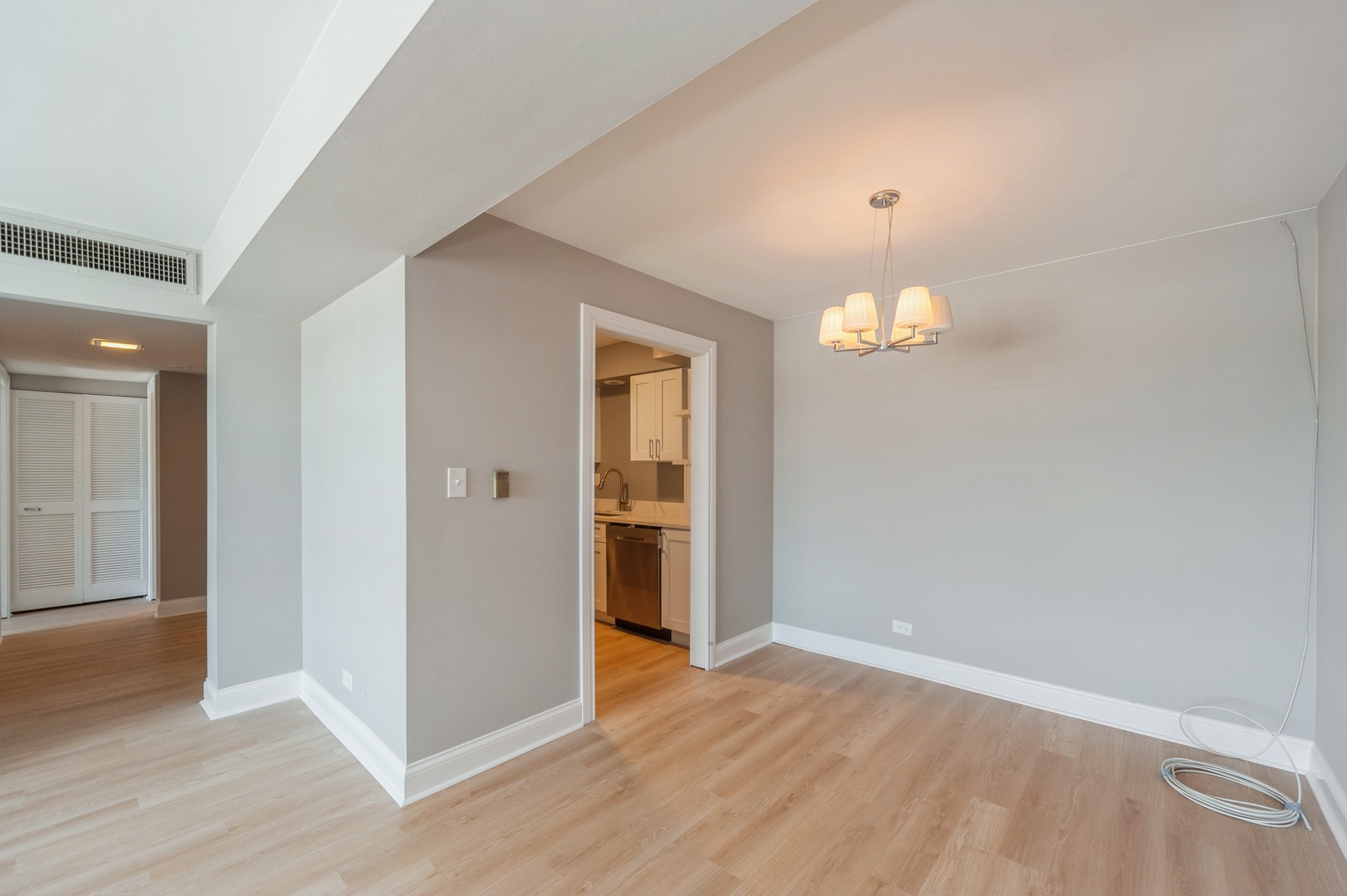 1455 Shermer Road, Unit 503C Northbrook, IL 60062 - Photo 3 of 11 an empty room with wooden floor and chandelier