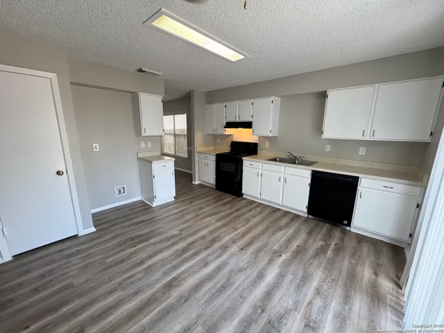 a kitchen with a refrigerator and a stove top oven