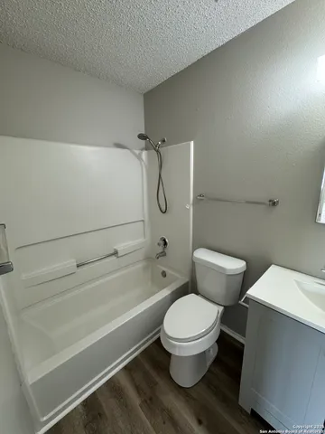 a white toilet and tub next to a bathroom sink