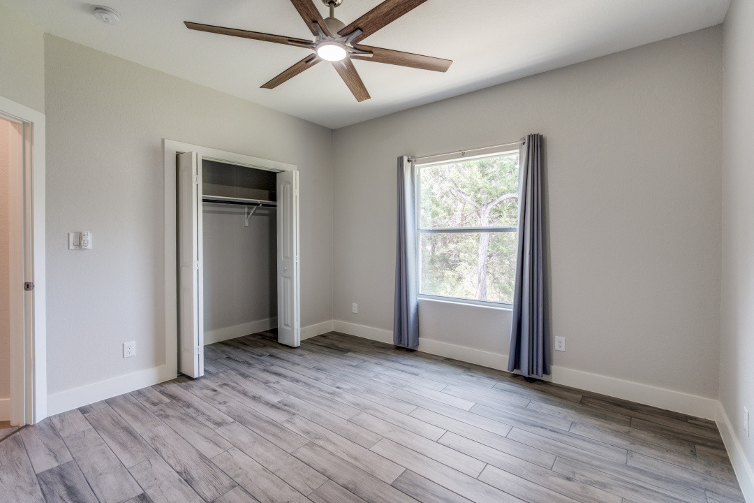 1848 Tanglewood Trail Spring Branch, TX 78070 - Photo 8 of 12 A quiet bedroom showcases wood-look tile flooring and an integrated ceiling fan for comfort.