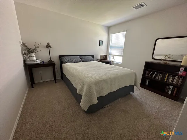 a bed sitting in a bedroom next to a window