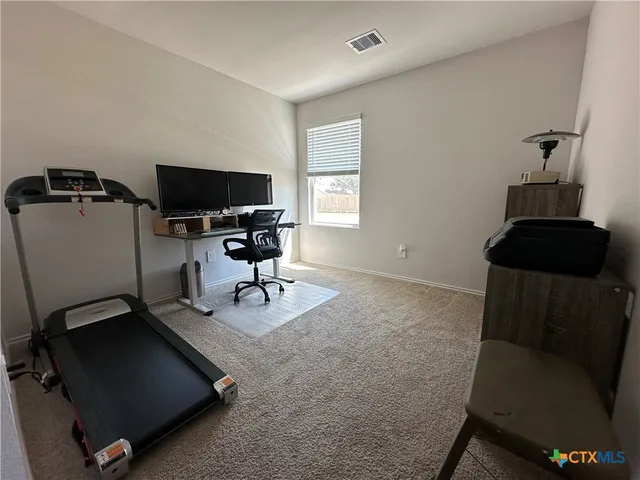 a view of a workspace with furniture and a window