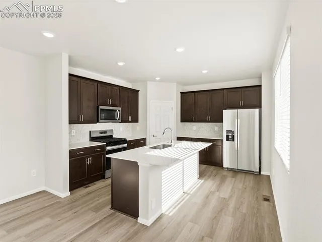 a kitchen with stainless steel appliances a stove a sink and a refrigerator