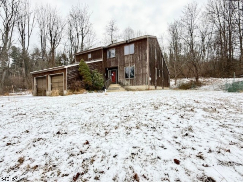 a front view of a house with a yard covered in snow