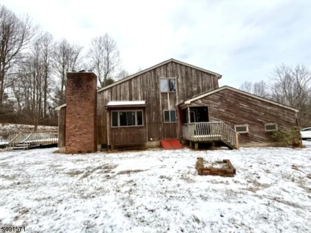 a front view of house with yard covered in snow