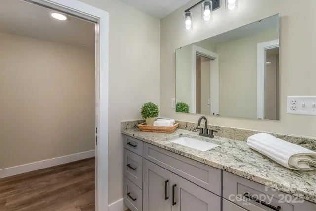 a bathroom with a granite countertop sink and a mirror