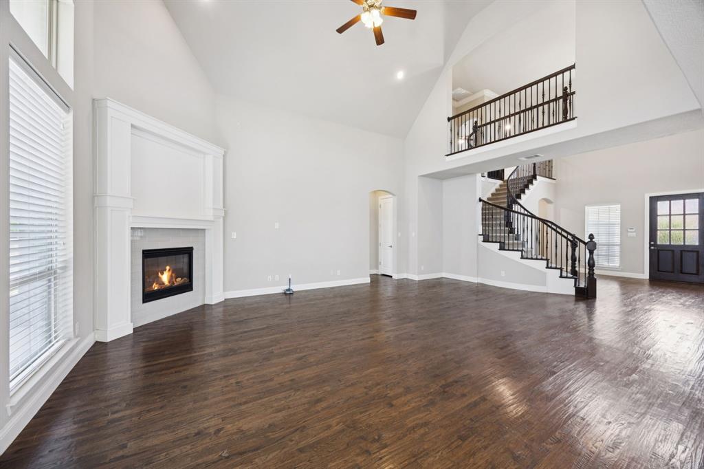 965 Touchstone Road Frisco, TX 75036 - Photo 6 of 36 a view of an empty room with wooden floor fireplace and a window