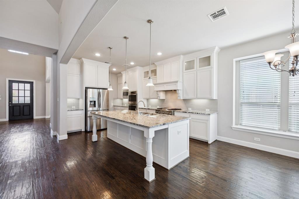 965 Touchstone Road Frisco, TX 75036 - Photo 8 of 36 a kitchen with stainless steel appliances granite countertop a stove a refrigerator and a fireplace