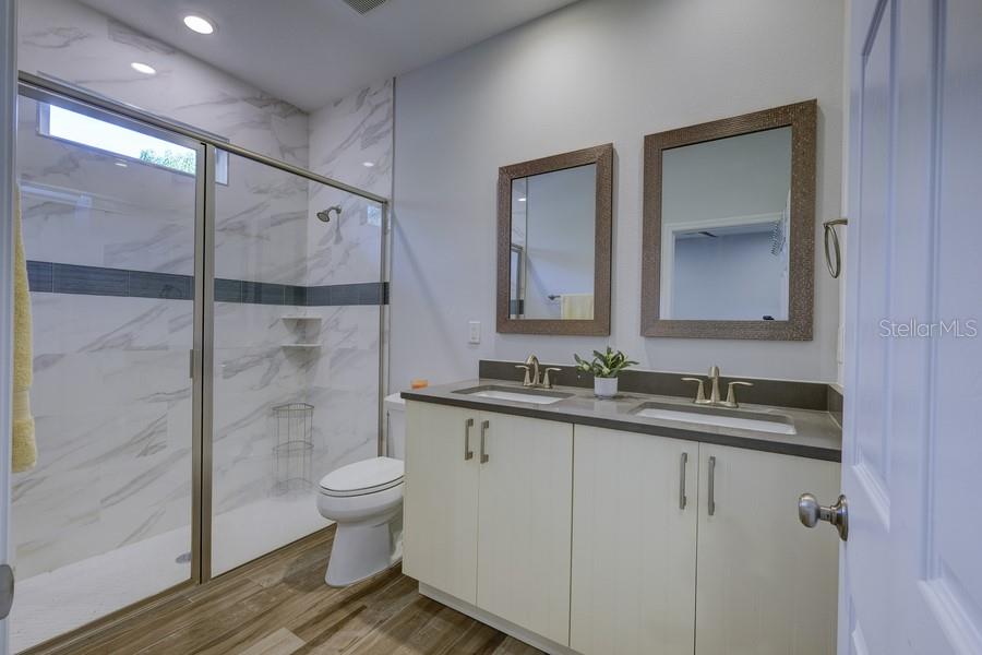 4436 Bliss Road Sarasota, FL 34233 - Photo 21 of 25 a bathroom with a granite countertop sink a toilet and a mirror