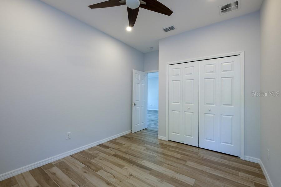 4436 Bliss Road Sarasota, FL 34233 - Photo 23 of 25 an empty room with wooden floor cabinet and ceiling fan