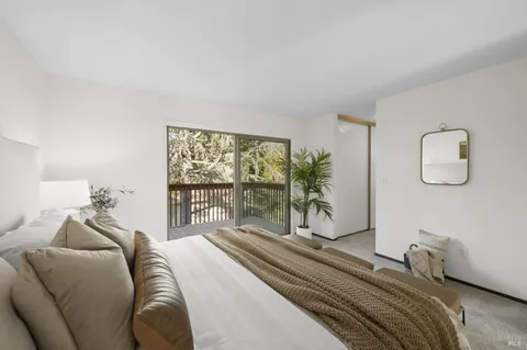 a bedroom with a large bed and a large window with balcony view
