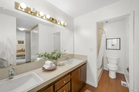 a bathroom with a granite countertop sink a toilet and a mirror