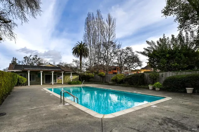 a view of a swimming pool with a patio and a yard