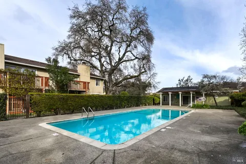 a view of a house with a swimming pool and a yard