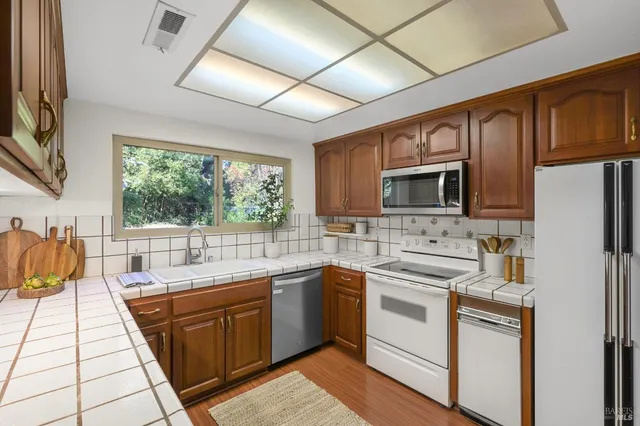 a kitchen with stainless steel appliances a sink stove and microwave