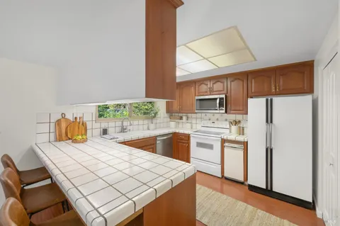 a kitchen with stainless steel appliances a stove a sink refrigerator and a microwave