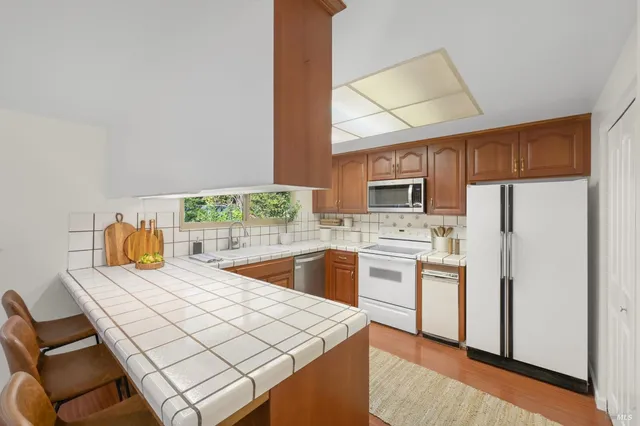 a kitchen with stainless steel appliances a stove a sink refrigerator and a microwave