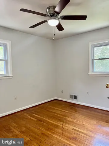 an empty room with a window and ceiling fan