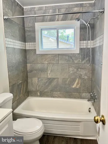 a bathroom with a toilet and a bath tub