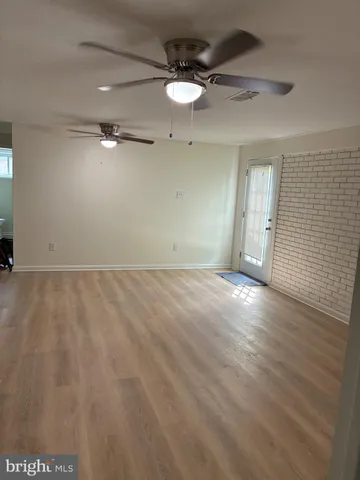 an empty room with a ceiling fan and window