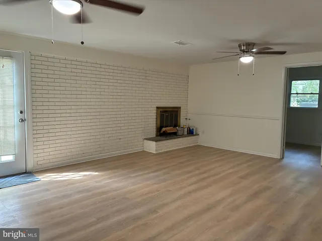 a view of a livingroom with wooden floor and a ceiling fan