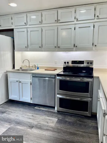 a kitchen with stainless steel appliances a stove and cabinets