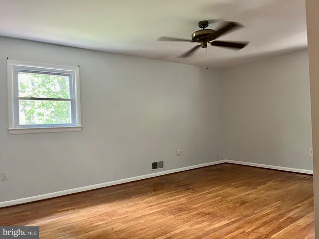a view of a room with wooden floor and fan